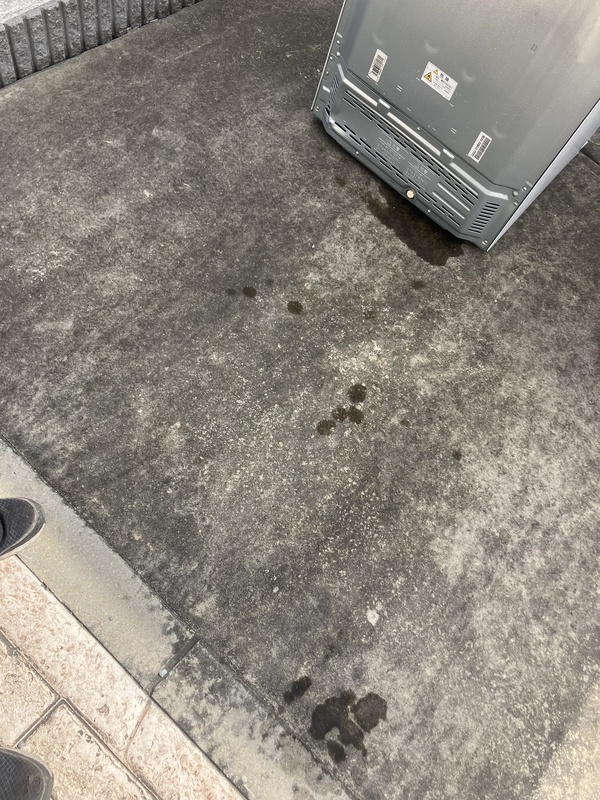 搬出した冷蔵庫のそばの地面に残った水滴